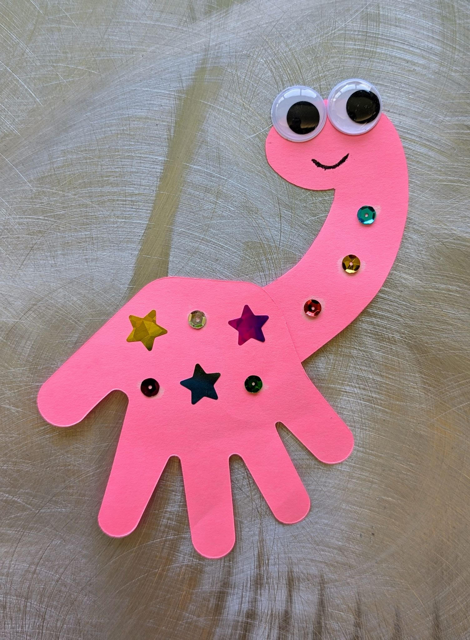 pink dinosaur craft with stickers